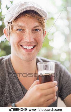 Portrait of man holding glass of beer View Large Photo Image Stock Photo - Portrait of man holding glass of beer. Fotosearch