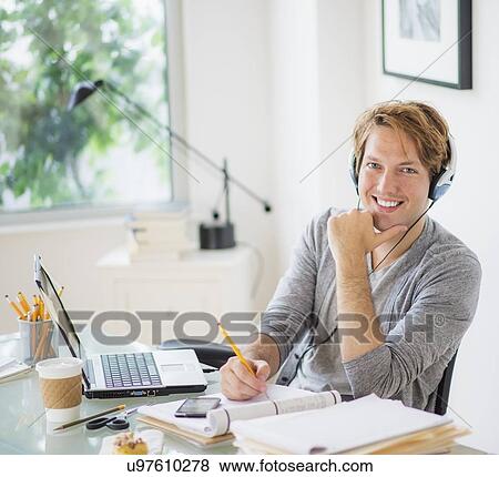 Stock Photo - Portrait of man multi-tasking in home office. Fotosearch