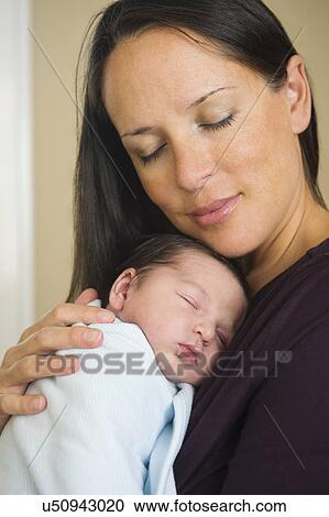 Stock Image - Portrait of mother holding newborn baby (0-11 months). Fotosearch