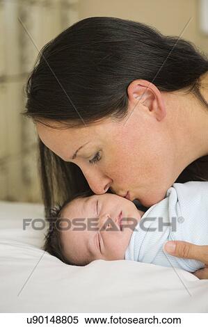 Portrait of mother kissing newborn baby (0-11 months) View Large Photo Image Stock Photography - Portrait of mother kissing newborn baby (0-11 months). Fotosearch