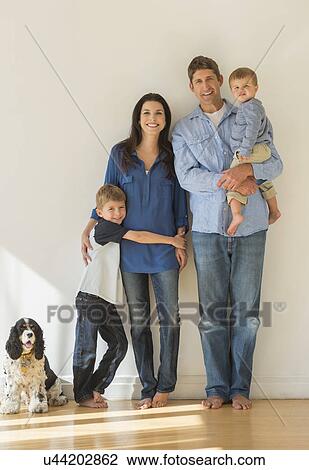 Stock Image - Portrait of parents with two sons (12-17 months, 6-7) and dog. Fotosearch