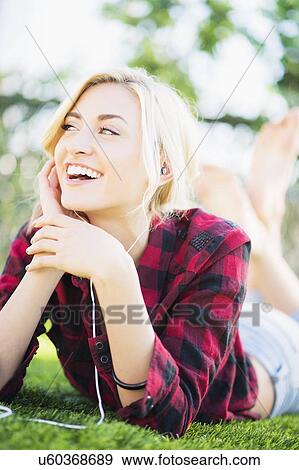 Portrait of teenage girl (16-17) lying on grass View Large Photo Image Stock Photo - Portrait of teenage girl (16-17) lying on grass. Fotosearch
