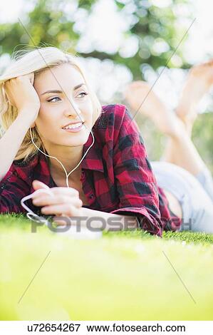 Portrait of teenage girl (16-17) lying on grass View Large Photo Image Stock Photo - Portrait of teenage girl (16-17) lying on grass. Fotosearch