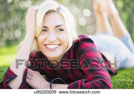 Portrait of teenage girl (16-17) lying on grass View Large Photo Image Stock Photo - Portrait of teenage girl (16-17) lying on grass. Fotosearch