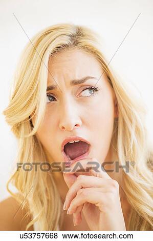 Stock Photo - Portrait of teenage girl (16-17) with finger on lips. Fotosearch