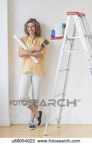 Stock Image - Portrait of woman doing home improvement. Fotosearch