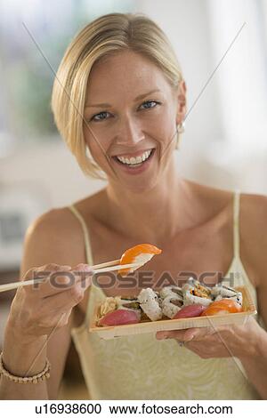 Portrait of woman eating sushi View Large Photo Image Stock Image - Portrait of woman eating sushi. Fotosearch