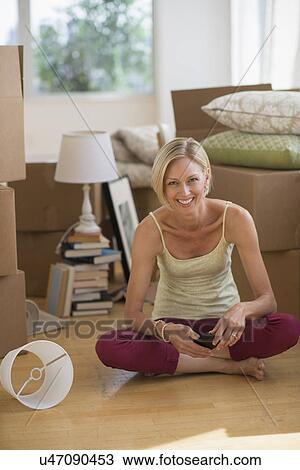 Portrait of woman sitting on floor of new home View Large Photo Image Stock Image - Portrait of woman sitting on floor of new home. Fotosearch