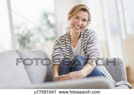 Portrait of woman sitting on sofa View Large Photo Image Stock Image - Portrait of woman sitting on sofa. Fotosearch