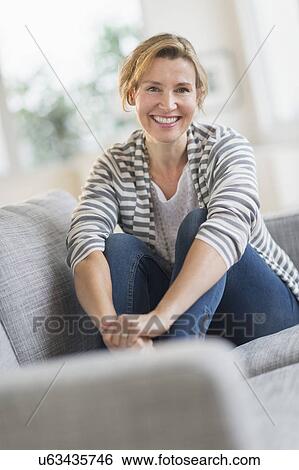 Portrait of woman sitting on sofa View Large Photo Image Stock Photograph - Portrait of woman sitting on sofa. Fotosearch