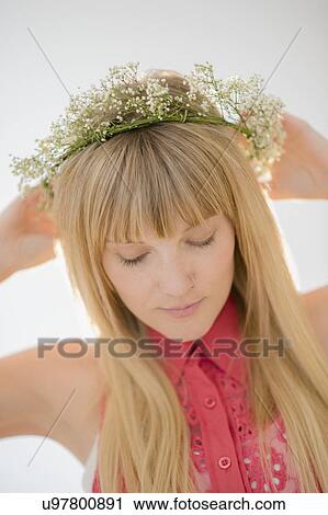 Stock Image - Portrait of woman wearing flower wreath. Fotosearch