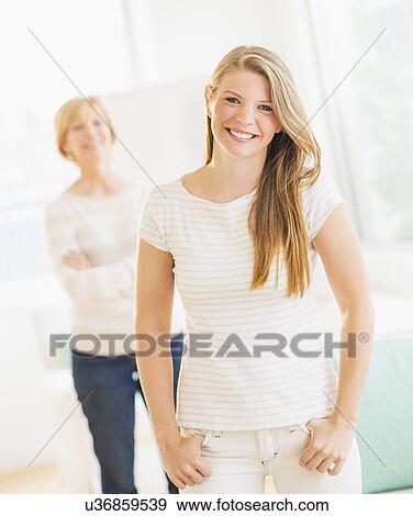 Stock Photo - Portrait of young woman with mother in background. Fotosearch