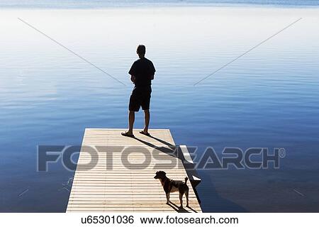 Rear view of man on jetty looking at view View Large Photo Image Stock Photograph - Rear view of man on jetty looking at view. Fotosearch