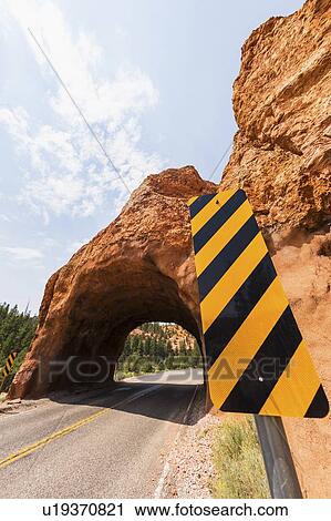 Stock Image - Road going under natural tunnel. Fotosearch