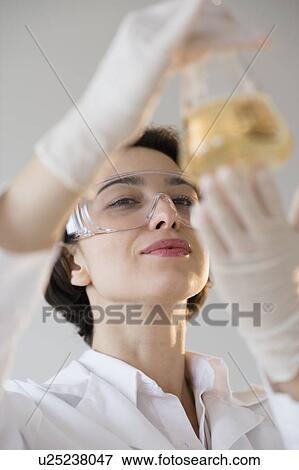 Stock Photo - Scientist examining liquid. Fotosearch
