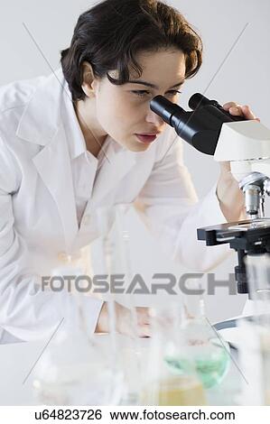 Stock Photograph - Scientist looking through microscope. Fotosearch