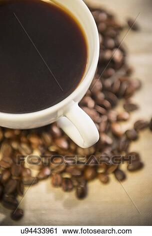 Stock Image - Studio shot of cup of coffee and roasted coffee beans. Fotosearch