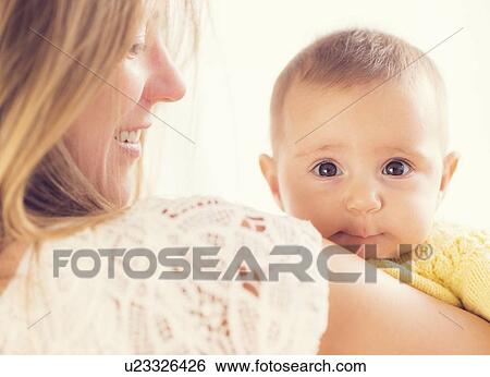 Stock Photograph - Studio Shot of mother holding daughter (2-5 months). Fotosearch