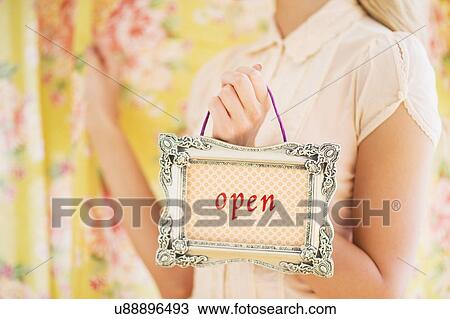 Stock Image - Teen (16-17) girl holding open sign. Fotosearch
