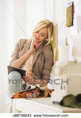 Stock Image - Teen (16-17) girl using tablet pc in design studio. Fotosearch