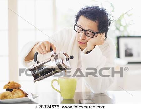 Stock Photograph - Teenage boy (16-17) eating breakfast. Fotosearch