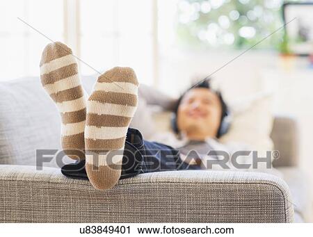 Teenage boy (16-17) lying on sofa and listening to music View Large Photo Image Stock Image - Teenage boy (16-17) lying on sofa and listening to music. Fotosearch