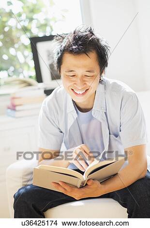 Picture - Teenage boy (16-17) reading book. Fotosearch
