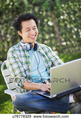 Teenage boy (16-17) using laptop in park View Large Photo Image Stock Photo - Teenage boy (16-17) using laptop in park. Fotosearch