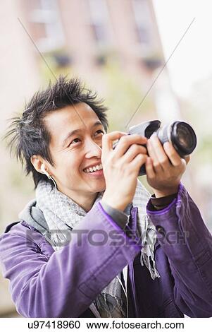 Stock Image - Teenage boy (16-17) with camera. Fotosearch