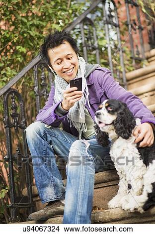 Teenage boy(16-17) taking picture of his dog View Large Photo Image Picture - Teenage boy(16-17) taking picture of his dog. Fotosearch
