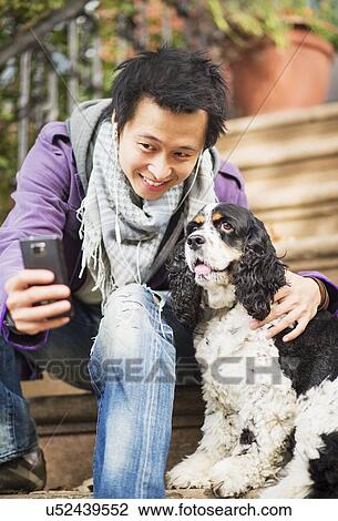 Teenage boy(16-17) taking picture of his dog View Large Photo Image Stock Image - Teenage boy(16-17) taking picture of his dog. Fotosearch