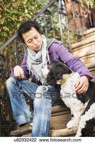Stock Image - Teenage boy(16-17) with dog. Fotosearch