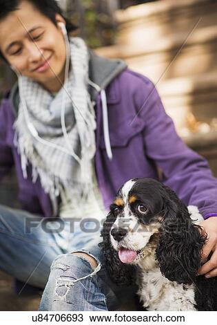 Stock Image - Teenage boy(16-17) with dog. Fotosearch