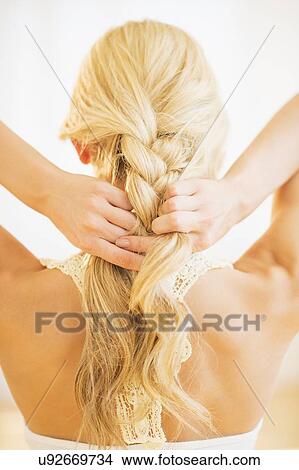 Teenage girl (16-17) braiding hair View Large Photo Image Picture - Teenage girl (16-17) braiding hair. Fotosearch
