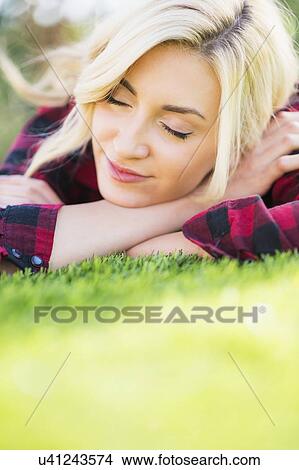 Picture - Teenage girl (16-17) sleeping on grass. Fotosearch