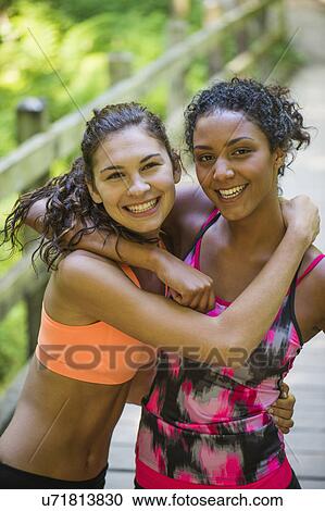 Two young women in sports clothing embracing View Large Photo Image Stock Image - Two young women in sports clothing embracing. Fotosearch