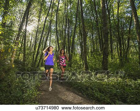 Two young women jogging in forest View Large Photo Image Stock Image - Two young women jogging in forest. Fotosearch
