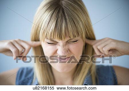 Stock Photography - Woman blocking ears with fingers. Fotosearch
