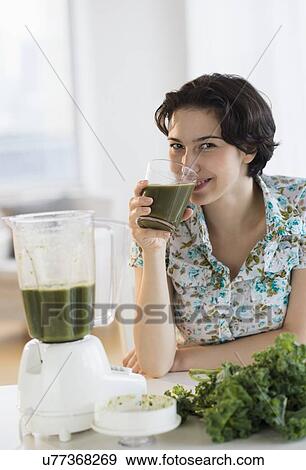 Stock Photo - Woman drinking kale juice. Fotosearch