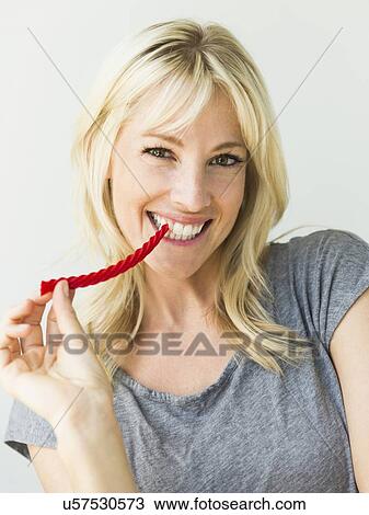 Stock Image - Woman eating candy. Fotosearch