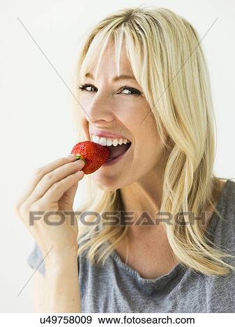 Stock Photo - Woman eating fresh strawberry. Fotosearch