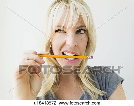 Woman holding pencil in her mouth View Large Photo Image Stock Image - Woman holding pencil in her mouth. Fotosearch