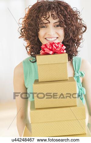 Stock Photo - Woman holding stack of gifts. Fotosearch