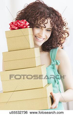 Stock Photograph - Woman holding stack of gifts. Fotosearch
