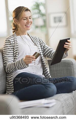 Stock Image - Woman holding tablet pc and credit card. Fotosearch
