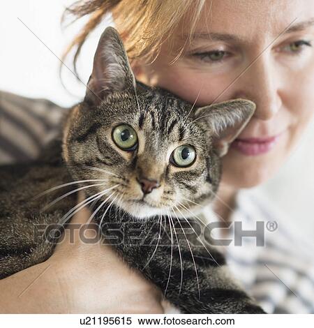 Stock Photography - Woman hugging cat. Fotosearch