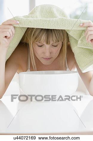 Woman inhaling steam from bowl View Large Photo Image Stock Photo - Woman inhaling steam from bowl. Fotosearch