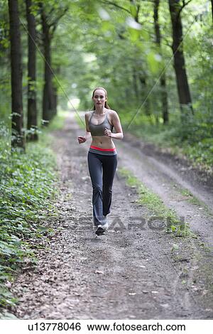 Woman jogging in forest View Large Photo Image Stock Photograph - Woman jogging in forest. Fotosearch