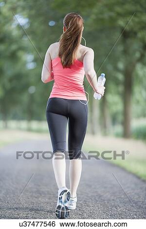 Woman jogging on road View Large Photo Image Stock Photograph - Woman jogging on road. Fotosearch