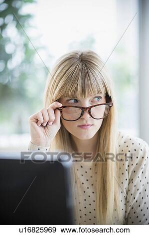 Woman looking above glasses View Large Photo Image Stock Photo - Woman looking above glasses. Fotosearch